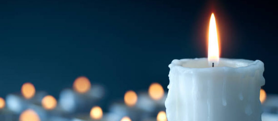 Melting candle on cool blue background